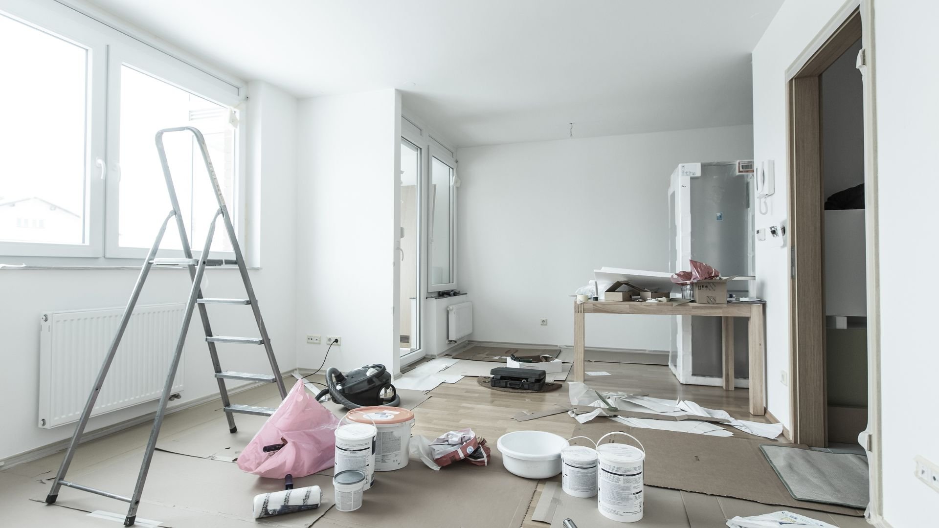 Room interior during renovation with painting supplies and stepladder